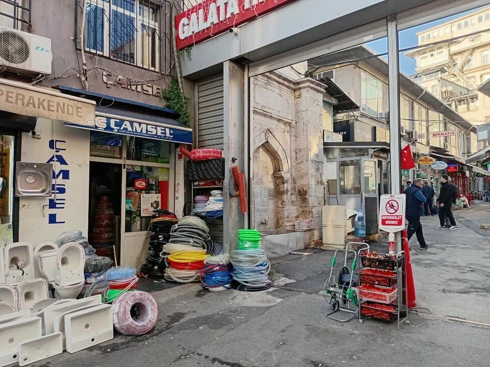 Çamsel Hortum mağazasının sokak cephesi ve önünde sergilenen hortum rulolarının fotoğrafı